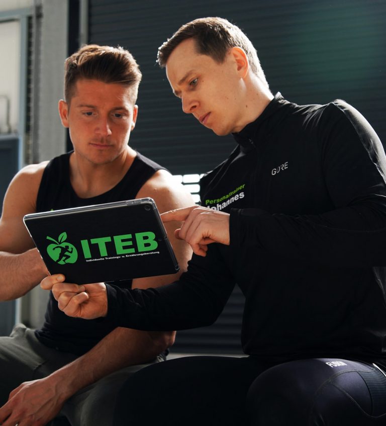 Johannes Bremer bespricht den Trainingsplan mit einem Sportler am Tablet